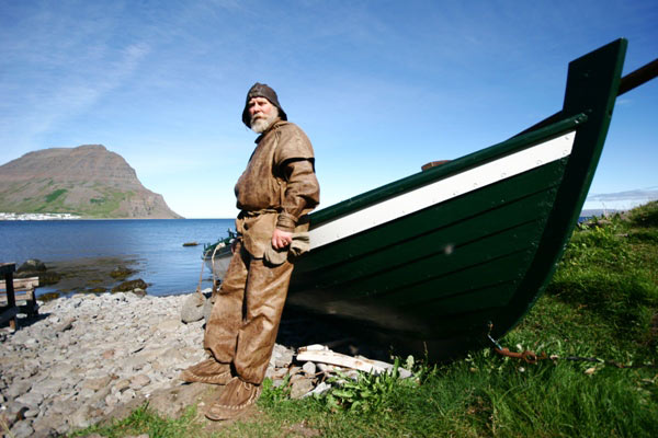 Podróżnych wita rybak ubrany w tradycyjny islandzki strój tamtych czasów